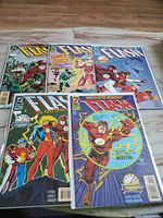 Five comic books featuring The Flash, laid out flat showing front covers