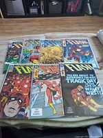 Photo showing seven Flash comic books laid out on the floor, visible cover art and condition shown.