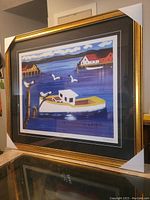 Front view of framed fine art print depicting a coastal harbour scene with boat and seagulls