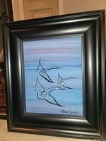 Framed painting showing four stylized birds flying against a blue-purple sky background. Signed 'R Knott 2018' in bottom right corner.