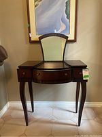 Front angled view of dark wood Bombay vanity table showing curved legs, three drawers with brass knobs and raised mirror section.