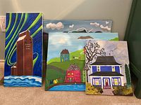 Four original paintings on canvas displayed together showing varied scenes including buildings and landscapes.