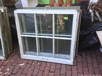 Front view of the 6-lite wooden window sash showing six individual glass panes and white painted wood frame with signs of age and wear.