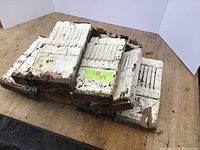 Stack of 9 wooden plinth blocks painted white with groove detailing, showing wear and chipping.