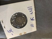 Front and back view of the 1877 British 3 Pence coin in protective holder.