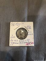 Close-up angled view of the obverse side and portion of the handwritten notes including pricing.