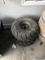 Two stacked Dunlop ATV tires mounted on rims, showing overall size and condition