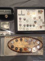 Framed display with Canadian provinces coins and crests, 1867-1992; 1999 Millennium Canada coin set box and coins visible