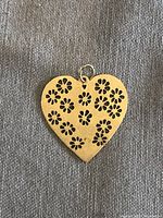 14K floral cutout heart charm on fabric background