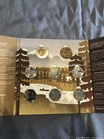 Front view of the open mint set folder showing eight Canadian coins arranged within a nature-themed background and protective blisters.
