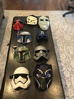 Close-up of bottom six masks: Boba Fett helmet, silver and black mask resembling Captain Phasma, First Order Stormtrooper helmet, white Stormtrooper helmet, and Black Panther mask.
