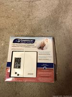 Front view of packaging box showing the Garrison 7 Day Programmable Thermostat with image of the device, branding, and key features.
