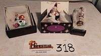 Three Christopher Radko Christmas ornaments in original boxes arranged on table; includes Santa riding polar bear, blue Santa with pack, and grand stand