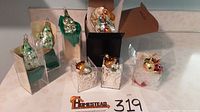 Several fine glass ornaments including three Christmas trees, two mushrooms, two small bird ornaments and one ladybug, arranged with protective packaging.