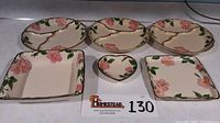 Top-down image showing the full set of Franciscan Desert Rose serving pieces arranged on a flat surface with lot label. Includes three round divided plates, one square low plate, one open bowl, and one heart dish featuring pink roses and green leaves on a cream background.