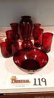 Complete collection of vintage ruby red glass vases, bowls, and drinking glasses shown together on a flat surface.