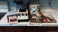 Full lot including Vita-Mix blender, Bamix hand blender, Sheffield carving set, instruction booklets, and recipes