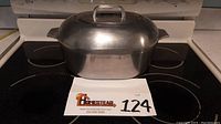 Front view of the covered oval Dutch oven roaster on stovetop with lot number in front.
