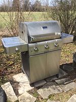 Frontal view of the stainless steel Saber grill on paved patio