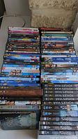 Top-down photo of multiple DVD cases stacked closely showing various titles and series collections
