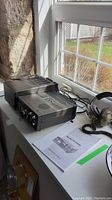 Transceiver, power supply, headset and manual displayed on windowsill