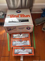 Main shot of the large Lionel Tank Train box with three additional tank car boxes positioned in front.