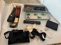 Overview of lot showing leather sheaths, wallet, trays of jewelry and bow ties