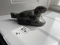 Front side profile view of stone walrus carving on windowsill