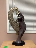 Side view of the statue showing the wing detail and flowing draped garment.