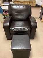 Front view of dark brown faux leather armchair with separate matching ottoman in front.
