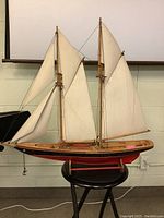 Front and side view of the wooden model sail ship showing sails, rigging, and stand.