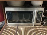 Front view of stainless steel Hamilton Beach microwave showing door and control panel area