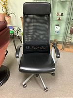 Front view of the black high back office chair showing mesh backrest and faux leather seat