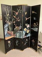 Front side of the four-panel screen showing peacocks, bamboo, and birds with detailed rock and floral painting on a black background.