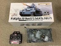 Photo showing the battle tank, remote control, and the original box with tank image and model name PzKpfw.IV Ausf.F2 Sd.Kfz.161/1.