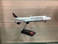 Side view of vintage Air Canada model airplane displayed on a black stand with Air Canada logo.