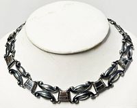 Front view of sterling silver choker necklace on display bust, showing detailed design alternating curved and rectangular links.