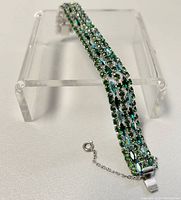 Full length front view showing three rows of green and aurora borealis rhinestones on silver-tone metal
