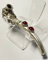 Side view of the silver plated dragon pipe showing dragon design details and two red stones on the stem.