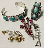 Photo showing all five pieces including cuff bangle, ring, and three brooches