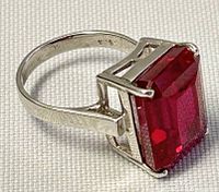 Close-up image showing side view of silver ring marked 925 with large rectangular garnet