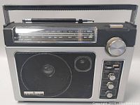 Front view of the GE Superadio showing speaker, frequency dial, tuning knobs, and handle.