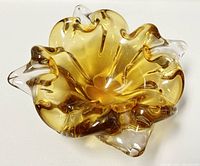 Front angle of the amber blown glass bowl showing ruffled edges and translucent amber to clear color transition.