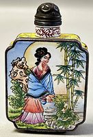 Front side of the rectangular enamel perfume bottle featuring a woman in blue and red robes next to bamboo and garden elements.