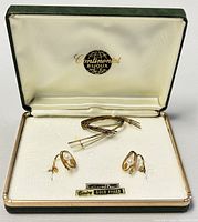 Set inside a Continental Bijoux box, includes a brooch and matching stud earrings with cultured pearl accents. Box is lined with cream satin.