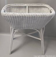 Front and side view of the Victorian white wicker plant stand showing the woven wicker basket and the curved legs.