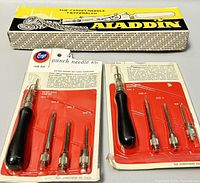 Two sealed Boye 4-punch needle kits with black handles and multiple punch needles, packaging with instructions and size labels.