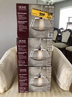 Three boxed Home Decorators Collection Mini Pendant light fixtures stacked, showing product images and dimensions.