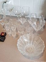 Overall view of assorted crystal stemware and decorative crystal items arranged on a counter.
