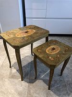Pair of large and small nesting tables on tiled floor